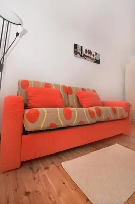 an orange couch sitting in a living room at Apartments Tonkli in Logje