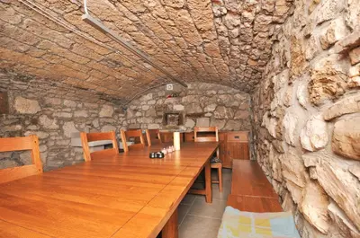 a wooden table in a room with a stone wall at Apartments Tonkli in Logje