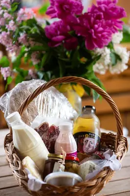 a basket filled with food and a vase of flowers at Korošec Apartments and Wellness Centre in Mozirje