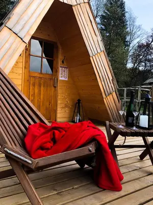 a red blanket laying on a hammock in a cabin at Korošec Apartments and Wellness Centre in Mozirje
