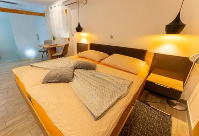 a bed with two pillows on it in a room at Korošec Apartments and Wellness Centre in Mozirje