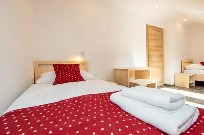 a bedroom with a red and white blanket on a bed at Bohinj Apartments Goldhorn Kingdom in Bohinj