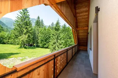 a balcony in a log cabin with a large window at Bohinj Apartments Goldhorn Kingdom in Bohinj