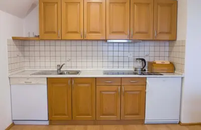 a kitchen with wooden cabinets and a sink at Apartments Pri Marjetki in Cerkno