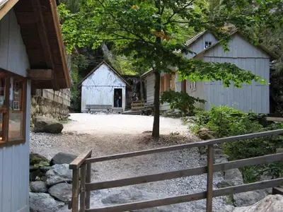 a barn with a fence in front of a house at Apartments Pri Marjetki in Cerkno