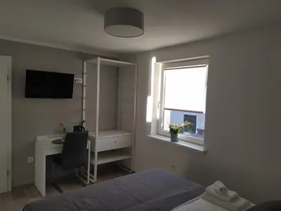 a bedroom with a bed and a desk and a window at Apartment Trubarjeva33, near Ljubljana, free parking in Velike Lašče
