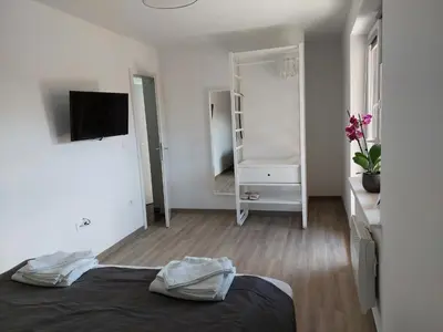 a white room with a bed and a mirror at Apartment Trubarjeva33, near Ljubljana, free parking in Velike Lašče