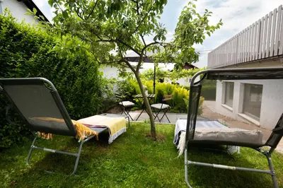 a bed and chairs in the grass in a yard at Funky soul studio in Žirovnica