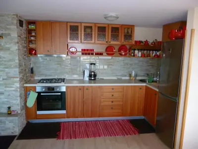 a kitchen with wooden cabinets and a stove and refrigerator at Chalet Bellevue Rogla in Zreče