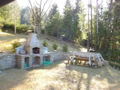 a small brick oven and a bench in a yard at Chalet Bellevue Rogla in Zreče