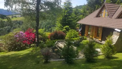 a house with a bench and flowers in the yard at Chalet Bellevue Rogla in Zreče