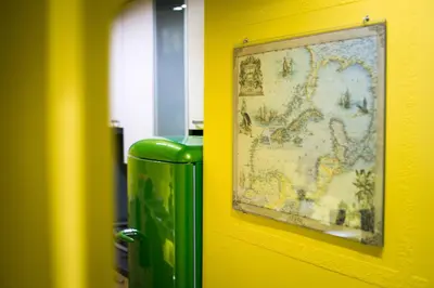 a green trash can next to a wall with a picture at Apartment Jacobs in Bled