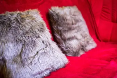 a pair of faux fur mittens sitting on a red couch at Apartment Jacobs in Bled