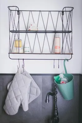 a shelf above a sink with towels and a bucket at NATURALINA HOLIDAY HOUSE in Tribussa Superiore