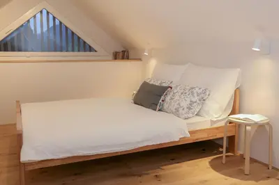 a small bed in a room with a window at Apartments Alteri Domi in Bohinj