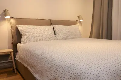 a bed with white sheets and pillows in a bedroom at Apartments Alteri Domi in Bohinj
