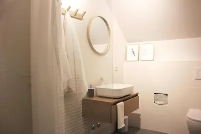 a white bathroom with a sink and a mirror at Apartments Alteri Domi in Bohinj