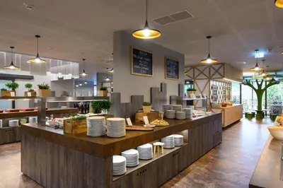 a restaurant with a counter with plates on it at Terme Olimia - Hotel Breza in Podčetrtek