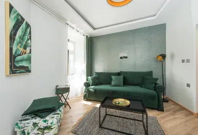 a living room with a green couch and a table at Royal Vega Apartment in Ljubljana