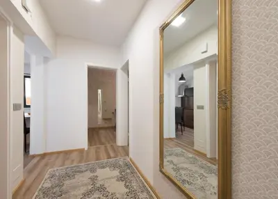 a hallway with a mirror and a rug at Royal Vega Apartment in Ljubljana