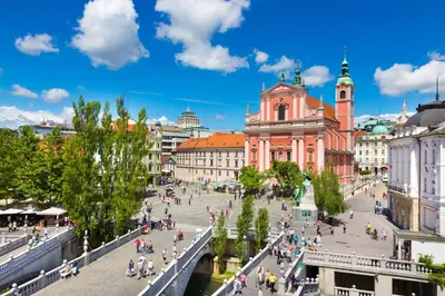 a group of people walking around a street in a city at Royal Vega Apartment in Ljubljana