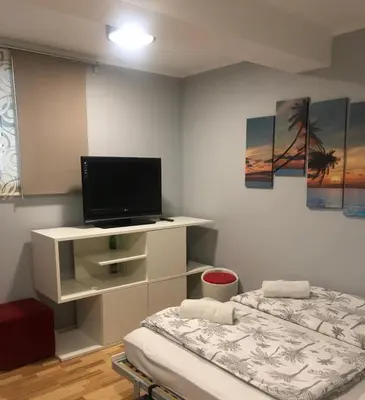 a room with two beds and a flat screen tv at Apartment Red Square in Ljubljana