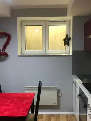 a kitchen with a red table and a window at Apartment Red Square in Ljubljana