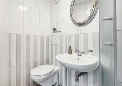 a white bathroom with a toilet and a sink at Blissful Loft Tivoli in Ljubljana