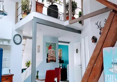a room with white walls and a staircase with a clock at Blissful Loft Tivoli in Ljubljana
