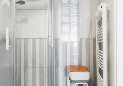 a white bathroom with a toilet and a shower at Blissful Loft Tivoli in Ljubljana