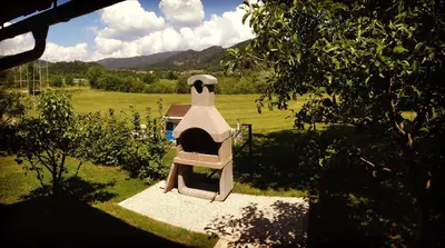 a small outdoor oven in a yard with a field at Apartment Studio Van Bakel Gerard in Bled