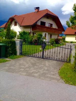 a fence in front of a house with a house at Apartment Studio Van Bakel Gerard in Bled