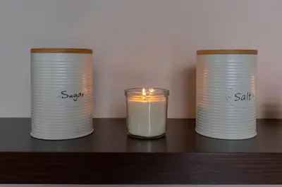 a candle and two containers on a table at Apartma Relax Gaja - In the most beautiful city in the world in Ljubljana