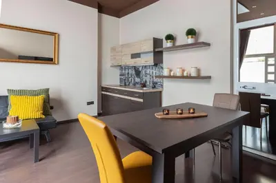 a kitchen and dining room with a table and yellow chairs at Apartma Relax Gaja - In the most beautiful city in the world in Ljubljana