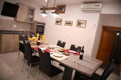 a dining room with a table and chairs with wine bottles at Apartments Slap in Slappe dʼIdria