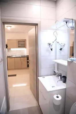 a white bathroom with a sink and a toilet at Apartments Slap in Slappe dʼIdria