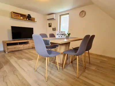 a dining room with a table and chairs and a television at River View Apartments Irena in Bohinj