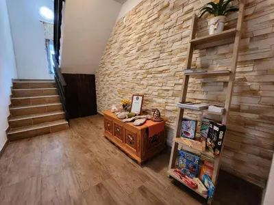 a room with a brick wall and a book shelf at River View Apartments Irena in Bohinj