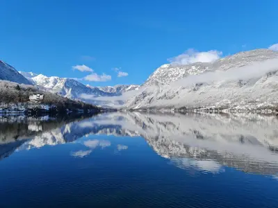 a view of a lake with snow covered mountains at River View Apartments Irena in Bohinj