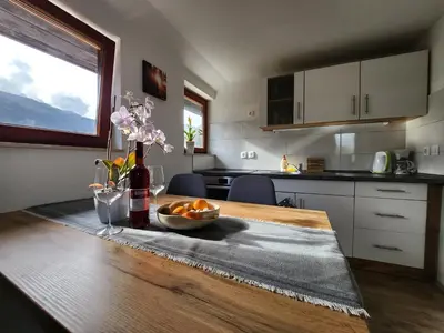 a kitchen with a table with a bowl of oranges on it at River View Apartments Irena in Bohinj