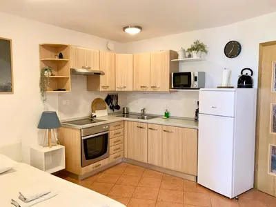 a kitchen with wooden cabinets and a white refrigerator at Apartment Bc in Bovec