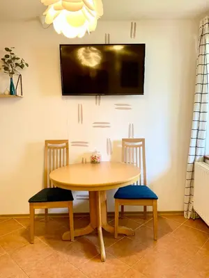a table with two chairs and a tv on a wall at Apartment Bc in Bovec