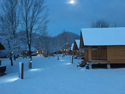 a snow covered street with a house and a mountain at Camp Podgrad Vransko in Vransko