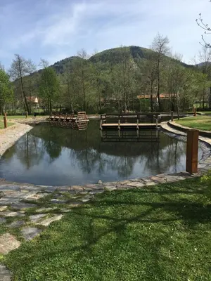 a bridge over a pond with benches in a park at Camp Podgrad Vransko in Vransko