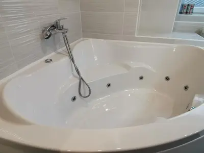 a white bath tub with a faucet in a bathroom at Stylish Apartment with Castle View & Free Parking in Ljubljana