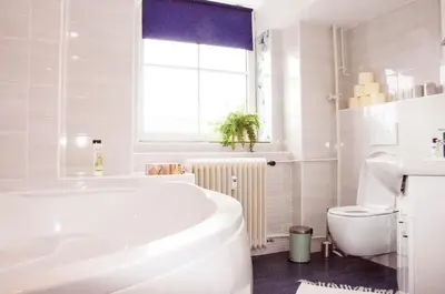 a white bathroom with a tub and a toilet at Stylish Apartment with Castle View & Free Parking in Ljubljana