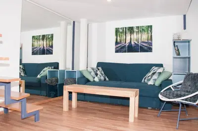 a living room with a blue couch and a table at Stylish Apartment with Castle View & Free Parking in Ljubljana
