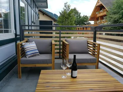 a table with two chairs and a bottle of wine at Apartments ViTa in Kranjska Gora
