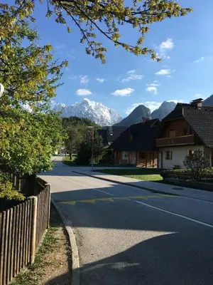 an empty street with mountains in the background at Apartments ViTa in Kranjska Gora