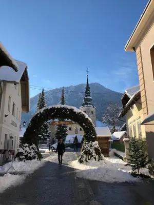 a man walking down a street under an arch in the snow at Apartments ViTa in Kranjska Gora